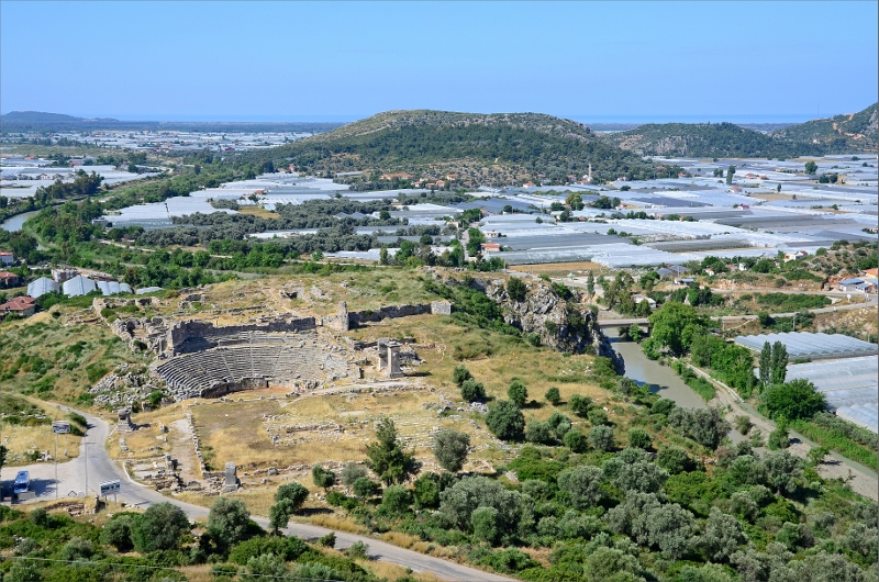 Vy från Aktopolis över teatern vid Xanthos ruiner, dalen med växthus samt Patara Beach i bakgrunden.